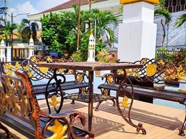 brun guld järn träsnideri bänk med arabicum arkitektur i madiun indonesien parkera, solig väder. foto