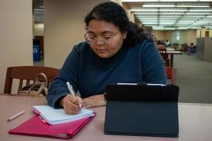 student som studerar i biblioteket foto