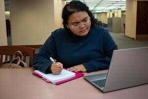 student som studerar i biblioteket foto