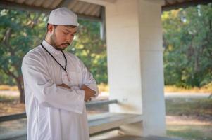 ung asiatisk muslim man bön- på solnedgång, ramadan festival begrepp foto