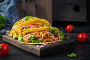 mexikansk tacos med majs tortilla. tortilla med kyckling kött, majs, sallad och lök foto