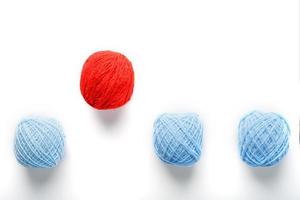 en unik röd boll hoppar ut av en rad av identisk ull bollar. abstrakt begrepp av ledarskap, foto