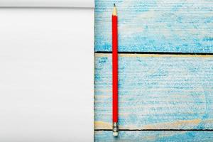 anteckningsbok för skrivning med en röd penna på en blå bakgrund. fri tömma Plats för skrivning på en tom ark av en anteckningsbok,. foto