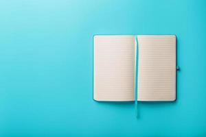 öppen anteckningsbok, en bok med tom och tom sidor på en blå bakgrund, topp se. foto
