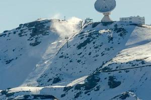 se av de åka skidor tillflykt i de hög snöig bergen Nästa till de astronomisk observatorium, lyssnande i de kosmos. foto