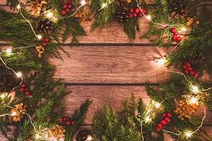 jul bakgrund av gran kvistar dekorerad med fe- lampor på mörk brun trä, ram med kopia Plats foto