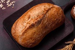 en limpa av brun bröd med korn av spannmål på en trä- skärande styrelse foto