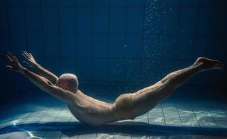 atletisk sport man under vattnet i de simning slå samman. sporter, yoga, fri dykning begrepp foto
