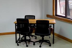 kontor skrivbord tillverkad av trä med en svart arbete stol foto