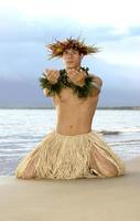 manlig hula dansare knäböjer i en hawaiian utgör av dyrkan. foto
