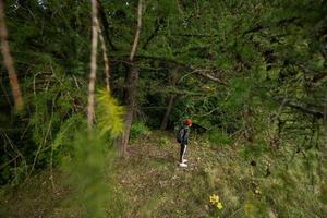 pojke med ryggsäck i vild skog vandring. foto