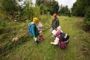 mor och barn sökande svamp i de vild skog. foto