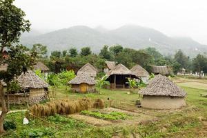 se på trä- hus och trädgård på en bakgrund av bergen i molnig väder. pai, mae hong snart provins, thailand. foto