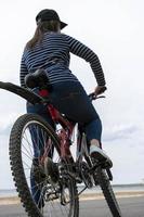 ung Söt kvinna med stor höfter stannade på en cykel, ser någonstans foto