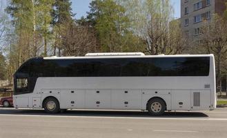 vit turist buss stående på en trafik ljus i de stad foto