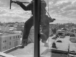 fönster rengöringsmedel på höghus byggnader. industriell klättrare foto