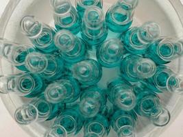 glas medicinsk ampull injektionsflaska för injektion. medicin är flytande natrium klorid med av vattenhaltig lösning i ampulla. stänga upp. flaskor ampull Flerfärgad foto