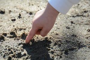 barn finger spelar med sand foto