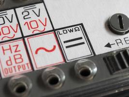 elektrisk symbol på årgång analog multimeter foto