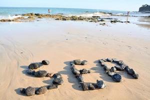 strand se med stenar foto