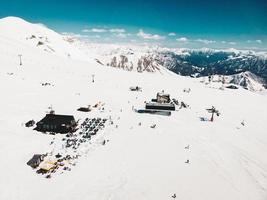 gudauri, georgien, 2021 - antenn se gudauri åka skidor tillflykt med turist hängande ut i runt om kupol Kafé i snö. resa Semester destination georgien, Kaukasus. foto