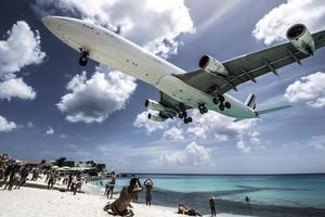 st. martin, 2013-turister tränger på maho beach när lågflygande flygplan närmar sig landningsbanan över strandlinjen foto