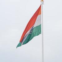 Indien flagga vajar högt på connaught plats med stolthet över blå himmel, Indien flagga vajar, indiska flaggan på självständighetsdagen och republikens dag i Indien, tilt up shot, viftande indiska flaggan, har ghar tiranga foto