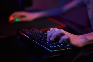 gamer spela dator spel, använda sig av rgb neon färgad tangentbord foto
