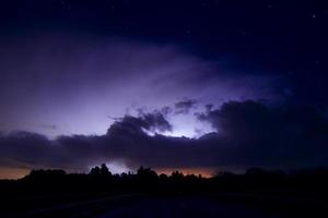 blixt- strejker genom storm moln belysande de natt himmel. foto