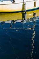 nöje båt med reflektioner i de vatten i de marina. vertikal bild. foto