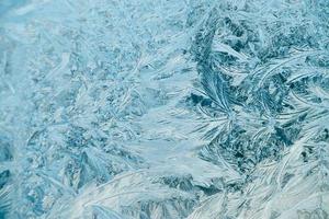 frostig mönster på glas. jul bakgrund. blå is på vinter- fönster. foto