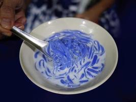 hög vinkel se, stänga upp thai traditionell efterrätt, ris spaghetti tillverkad från ris mjöl i särskild blå Färg med kall kokos grädde, lod chong foto