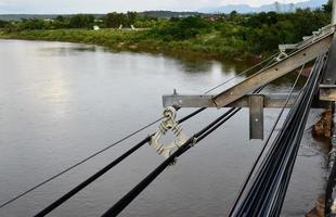 hängande och förvaring de lagring av hög Spänning kablar och fiber optisk kablar i de sida av betong flod broar i de avlägsen områden av sydöst Asien, mjuk och selektiv fokus. foto