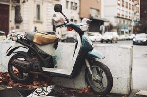 ett gammal motorcykel, rostig och bruten, övergiven i de mitten av de stad. foto