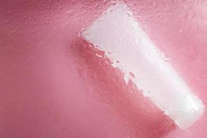 fuktgivande hud vård Produkter. ansikte och hand grädde under en glas yta med vatten på en rosa bakgrund. spa kosmetisk foto