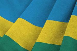 rwanda flagga med stor veck vinka stänga upp under de studio ljus inomhus. de officiell symboler och färger i baner foto