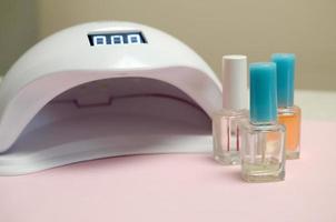 uv diod lampa lampor för naglar och uppsättning av kosmetisk nagel putsa för manikyr och pedikyr på pastell bakgrund foto