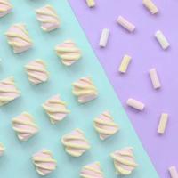 färgrik marshmallow lagd ut på violett och blå papper bakgrund. pastell kreativ texturerad mönster. minimal foto