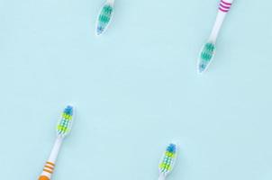 en massa av tandborstar lögn på en pastell blå bakgrund. topp se, platt lägga. minimal begrepp foto