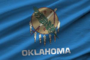 Oklahoma oss stat flagga med stor veck vinka stänga upp under de studio ljus inomhus. de officiell symboler och färger i baner foto