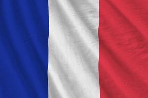 Frankrike flagga med stor veck vinka stänga upp under de studio ljus inomhus. de officiell symboler och färger i baner foto
