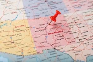 röd prästerlig nål på en Karta av usa, ny mexico och de huvudstad av santa fe. stänga upp Karta av ny mexico med röd kryssa foto