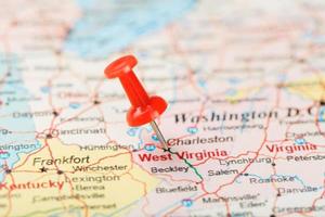 röd prästerlig nål på en Karta av usa, söder väst virginia och de huvudstad charleston. stänga upp Karta av söder väst virginia med röd kryssa foto