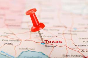 röd prästerlig nål på en Karta av usa, texas och de huvudstad texan. stänga upp Karta av texas med röd kryssa foto