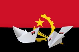 angola flagga avbildad på papper origami flygplan och båt. handgjort konst begrepp foto