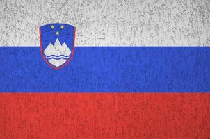 slovenien flagga avbildad i ljus måla färger på gammal lättnad putsning vägg. texturerad baner på grov bakgrund foto