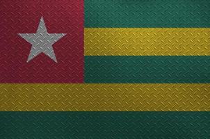 Togo flagga avbildad i måla färger på gammal borstat metall tallrik eller vägg närbild. texturerad baner på grov bakgrund foto