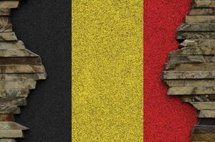belgien flagga avbildad i måla färger på gammal sten vägg närbild. texturerad baner på sten vägg bakgrund foto