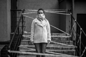 foto av en flicka i en mask. står på gatan med farovarningsband.