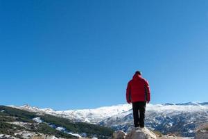 man stående på de kant av en klippa och väger naturens skapande i sierra nevada foto